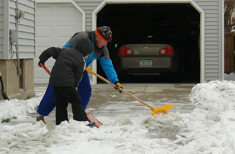 Granddad and Grandson shovel snow